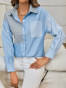 Close-up of classic collar and striped pocket detailing on blue cotton blend shirt