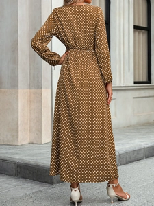 Back view of a retro brown polka dot maxi dress with long sleeves and a cinched waist design