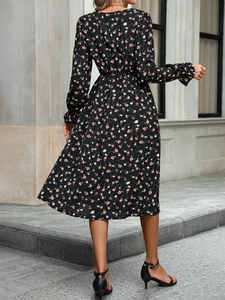 Détail d'une robe fleurie évasée avec taille élastique et manches longues à volants