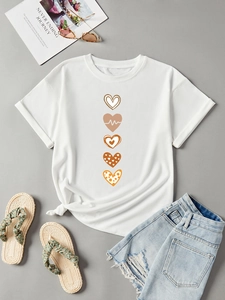 Flat lay of white cotton T-shirt featuring vertical earthy heart prints and denim shorts