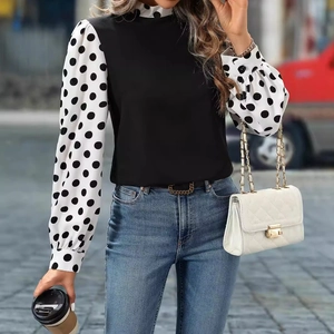 Elegant high-neck blouse with black body and contrast white polka dot puff sleeves