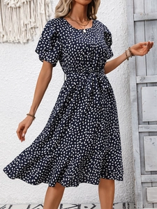 Detail of elegant summer floral dress with puff sleeves and tie waist in navy blue fabric
