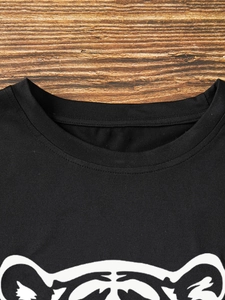 Detailed macro shot of the ribbed crew neck and stitching on this black cotton tiger t-shirt