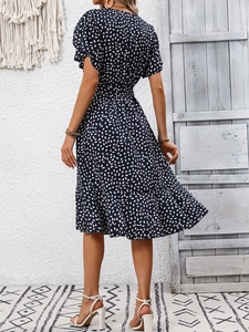Detail view of the elegant tiered ruffle hem on a navy blue floral midi dress