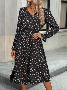 Détail d'une robe fleurie noire élégante avec col en V et taille élastiquée pour femme