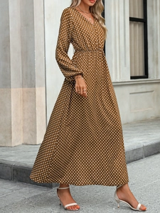 Detail of V-neck brown dress with white polka dots and elegant waist tie design