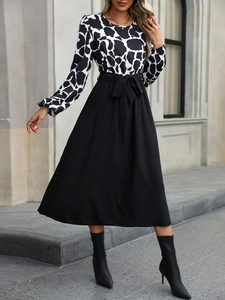 Detail of elegant two-tone dress featuring animal print bodice and waist tie bow