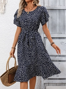 Detail of navy blue polka dot summer dress with ruffled sleeves and waist tie
