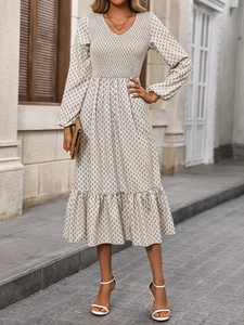 Detail of V-neck floral midi dress with smocked waist and ruffled hem on city street
