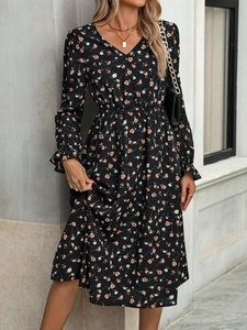 Détail d'une robe fleurie noire élégante avec taille élastique et poignets à volants