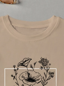 Detailed close-up of a camel cotton t-shirt featuring a black line floral graphic print