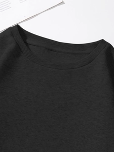 Detailed close-up of ribbed crew neck and stitching on a black long-sleeved T-shirt