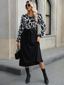 Detail of elegant two-tone dress with black white animal print top and bow waist tie