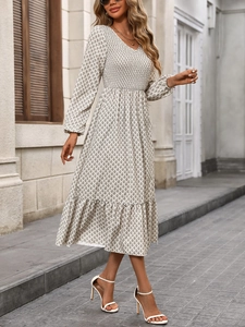 Detail of smocked waist and V-neck on a long sleeve elegant geometric print dress
