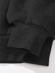 Close-up of black sweatshirt showing high-quality ribbed cuffs and knit fabric texture