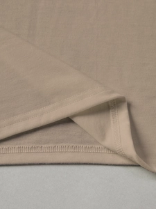 Detail view of the double-needle stitched hem on a khaki floral summer knit tee shirt