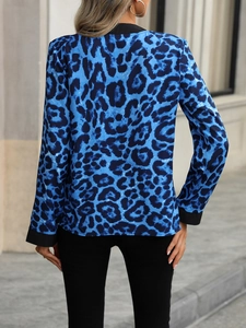 Rear view of a blue leopard print long sleeve blouse with black trim on cuffs