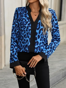 Detail of V-neck leopard print blouse with black contrast trim on collar and cuffs
