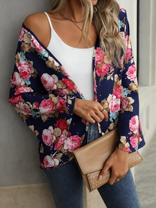 Close-up of floral print pattern on a dark blue V-neck blouse with bell sleeves