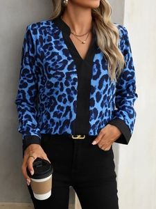 Detail of blue leopard print blouse featuring chic black contrast V-neckline and cuffs