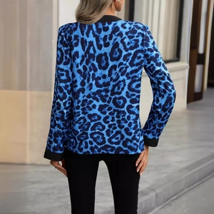 Women's blue leopard print V-neck blouse with black trim details shown from the back view