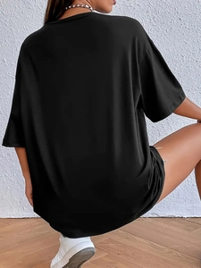Detailopname van oversized zwart katoenen T-shirt met verlaagde schouders aan de kant