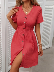 Detail of red V-neck dress featuring pleated texture and button-front design for summer