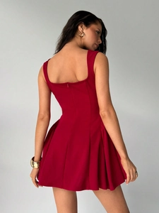 Close-up of the back hidden zipper and pleated A-line hem of the red sleeveless dress