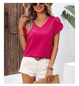 Detail of rose pink Swiss dot V-neck blouse with ruffled sleeves and textured fabric