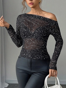 Detail of black sheer mesh top featuring sparkling star print and one-shoulder cut