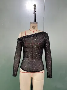 Detail of sheer black off-shoulder mesh top with sparkling rhinestone pattern