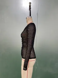 Detail of slim-fit black mesh top featuring white irregular dot patterns and sheer fabric