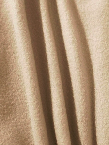 Close-up of soft beige fleece fabric showing premium plush texture and thick material