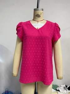 Detail of rose red Swiss dot fabric with V-neck and ruffled short sleeve textures