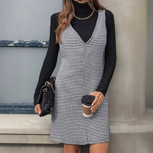 Houndstooth V-neck sleeveless dress paired with a black turtleneck in a chic urban style