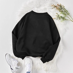 Flat lay of minimalist black crew neck sweatshirt with ribbed cuffs and hem