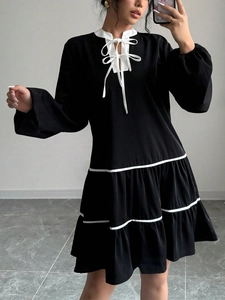 Detail of tiered black mini dress with white contrast collar and tiered skirt stripes