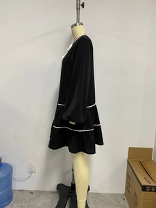 Detail of French style long sleeve tiered dress with contrast bow and white trim