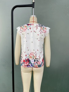 Détail du dos d'une chemise blanche à fleurs avec bordure en dentelle sur les épaules