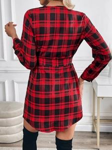 Detail view of the back of a red and black plaid long-sleeve dress with a waist belt