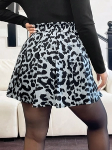 Detail view of high waisted pleated skirt with black and white leopard print pattern