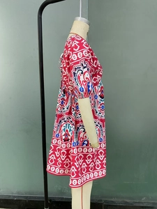 Gros plan d'une robe d'été bohème rouge avec motifs floraux bleus et manches bouffantes