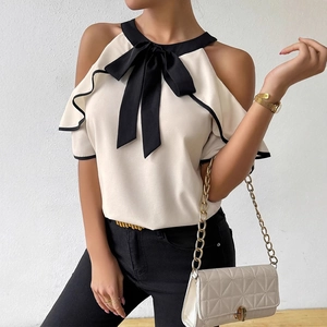 Elegant sleeveless blouse with a contrast black bow tie and feminine ruffled edges