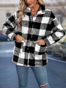 Close-up of black and white checkered plush jacket featuring button closure and soft texture