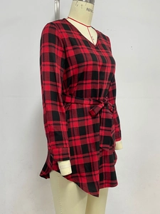 Detail of red and black plaid dress with elegant V-neck and adjustable waist tie