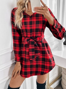 Detailed view of the red and black plaid pattern on a long-sleeve dress with waist tie