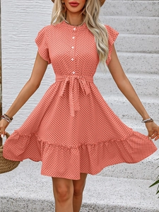Détail de la robe rose corail à pois avec manches à volants et ceinture à nœud à la taille