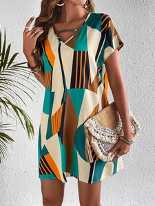 Dettaglio vestito estivo con scollo a V, motivi geometrici e pochette intrecciata