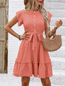 Détail de robe à pois avec manches à volants, boutons et ceinture à la taille