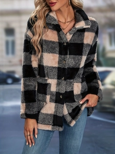 Close-up of thick plaid plush fabric texture and dark button on winter coat